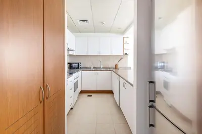 a kitchen with white cabinets and a long hallway at Frank Porter - Al Sidir 2 in Dubai