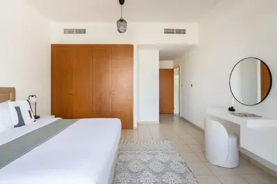 a bedroom with a bed and a mirror and a sink at Frank Porter - Al Sidir 2 in Dubai