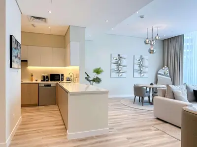 a kitchen and living room with a couch and a table at Sunset view apartment in Oceana in Dubai