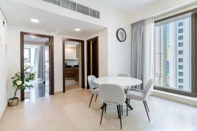 a dining room with a white table and chairs at Modern 1BR in Dubai Marina Near Metro & Beach in Dubai