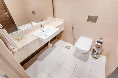 a white bathroom with a sink and a toilet at Modern 1BR in Dubai Marina Near Metro & Beach in Dubai