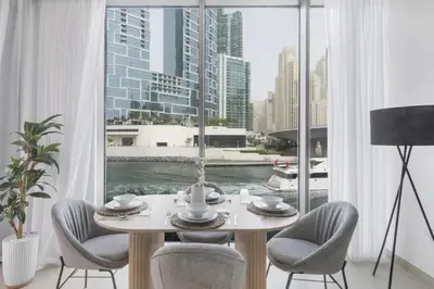 a dining room with a table and chairs and a large window at GuestReady - Contemporary with Ain Dubai View in Dubai
