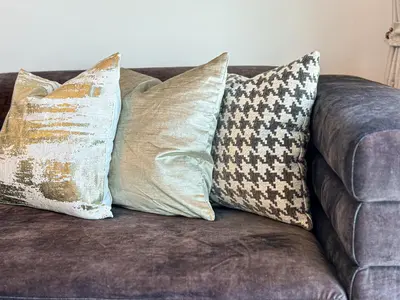 a brown couch with four pillows on it at HiGuests - Luxurious High-Rise Apartment With Stunning Views in Dubai