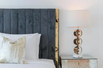 a bed with a white pillow and a lamp on a table at HiGuests - Luxurious High-Rise Apartment With Stunning Views in Dubai