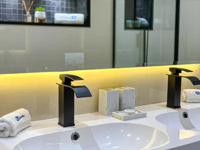 a bathroom sink with two faucets and a mirror at HiGuests - Luxurious High-Rise Apartment With Stunning Views in Dubai