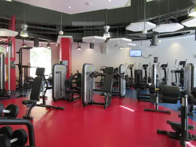 a gym with lots of cardio equipment on a red floor at GuestReady - Sea la Vie - Lux in JBR in Dubai