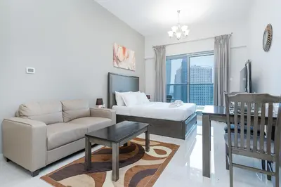 a living room with a couch and a bed at Spacious Studio I Close to Dubai Canal in Dubai