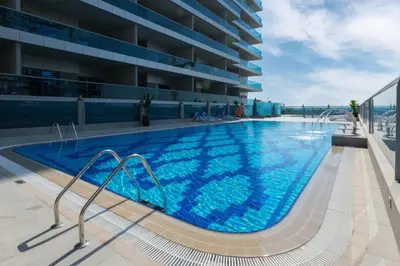 a swimming pool on the roof of a building at Spacious Studio I Close to Dubai Canal in Dubai