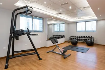 a gym with several exercise equipment in a room at Spacious Studio I Close to Dubai Canal in Dubai