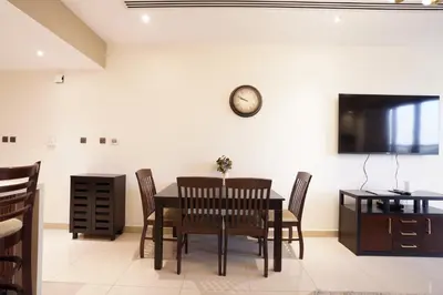 a dining room with a table and chairs and a tv at Mira Holiday Homes - Furnished 1 bedroom in Heart of Dubai in Dubai