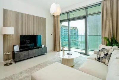 a living room with a couch and a tv at HomesGetaway-Luxury 2Br Apartment in Beach Vista Tower 2 in Dubai