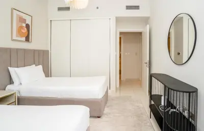 two beds in a room with a mirror and a crib at HomesGetaway-Luxury 2Br Apartment in Beach Vista Tower 2 in Dubai