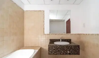 a bathroom with a sink and a tub and a mirror at 360 Vacation - Spacious 3BR Close to the Beach I Rimal1 JBR in Dubai