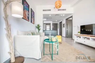 a living room with a white couch and a table at Vibrant 1BR in Bella Rose Al Barsha South by Deluxe Holiday Homes in Dubai