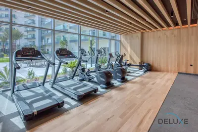 a gym with a row of treadmills in a building at Vibrant 1BR in Bella Rose Al Barsha South by Deluxe Holiday Homes in Dubai