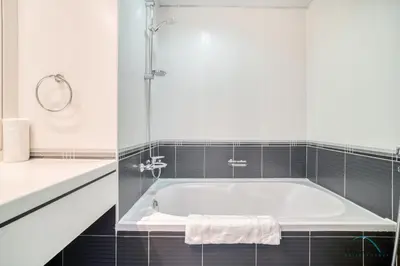 a white bathroom with a tub and a shower at Harmonious 1BR at Al Shera Tower JLT by Deluxe Holiday Homes in Dubai