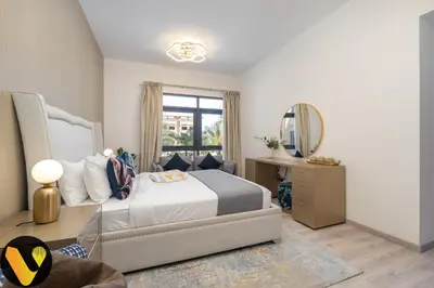 a bedroom with a bed and a table and a mirror at Vogue The Greens Al Sidir near Mall of The Emirates, Three Bedroom Apartment with Balcony and full access to all amenities in Dubai