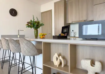 a kitchen with a counter with bar stools and a tv at Stunning 1BR in Stella Maris, City View, Marina in Dubai