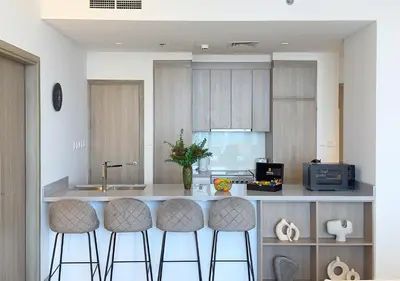 a kitchen with three bar stools and a counter at Stunning 1BR in Stella Maris, City View, Marina in Dubai