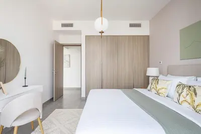 a bedroom with a large white bed and a desk at Frank Porter - Stella Maris in Dubai