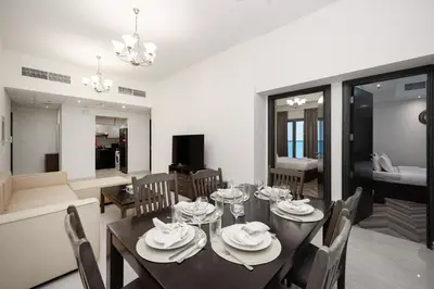a dining room with a black table and chairs at Stylish 4BR with Jacuzzi, Sauna & Prime Amenities in Dubai