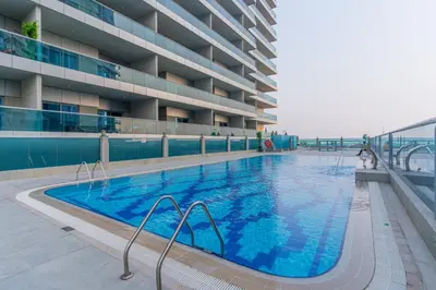 a large swimming pool in front of a building at Stylish 4BR with Jacuzzi, Sauna & Prime Amenities in Dubai
