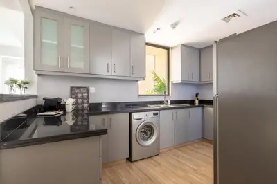 a kitchen with white cabinets and a washer and dryer at Frank Porter - Rimal 1 in Dubai