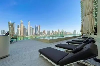 a row of chaise lounges on the roof of a building at Private Beachfront 1 Bed With 180 view of Marina Skyline in Dubai
