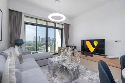 a living room with a couch and a tv at Vogue Emirates Hills, Vida The Hills Residence near Marina and JBR, One Bedroom Apartment with Balcony, Golf Club and City Skyline View, Access to all Amenities in Dubai