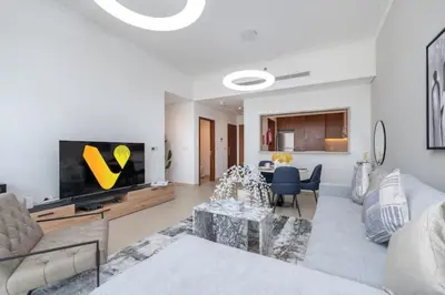 a living room with a couch and a tv at Vogue Emirates Hills, Vida The Hills Residence near Marina and JBR, One Bedroom Apartment with Balcony, Golf Club and City Skyline View, Access to all Amenities in Dubai