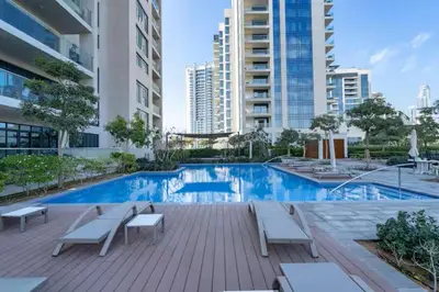 a swimming pool in a building with benches and buildings at Vogue Emirates Hills, Vida The Hills Residence near Marina and JBR, One Bedroom Apartment with Balcony, Golf Club and City Skyline View, Access to all Amenities in Dubai