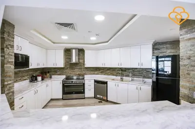 a large kitchen with white cabinets and appliances at Keysplease Upgraded 3 B/R + Nanny Beach Access, Palm Jumeirah in Dubai