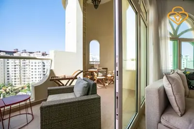 a balcony with two chairs and a table on a building at Keysplease Upgraded 3 B/R + Nanny Beach Access, Palm Jumeirah in Dubai