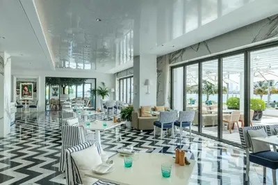 a restaurant with tables and chairs and a lobby at Elegant Palm Jumeirah Retreat with Breathtaking Sea Views By AYA Boutique in Dubai