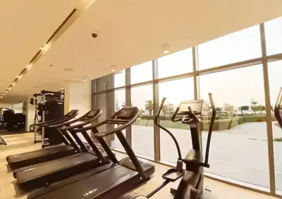 a gym with several cardio machines in a room with a large window at Elegant Palm Jumeirah Retreat with Breathtaking Sea Views By AYA Boutique in Dubai