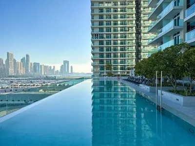 a swimming pool in front of a tall building at Glamorous 3BR with Marina view in Dubai