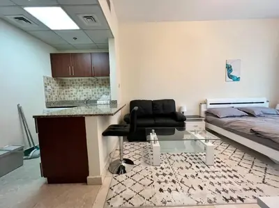 a bedroom with a black chair and a bed at Studio - Steps from Downtown in Dubai