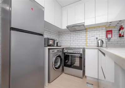 a kitchen with a refrigerator and a washing machine at 151 Residence Jumeirah Gardens in Dubai