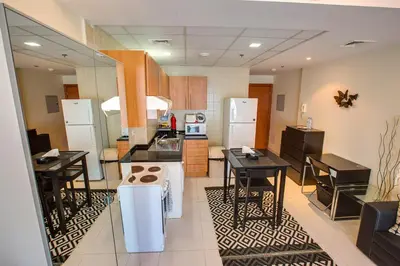 a kitchen with black tables and white appliances at Beautiful Studio on 10 floor of Marina View Tower in Dubai