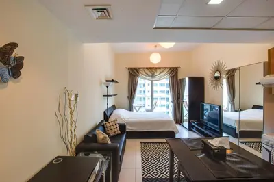 a room with a living room with a bed and a tv at Beautiful Studio on 10 floor of Marina View Tower in Dubai