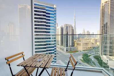 a table and chairs on a balcony with a view of a city at Vacationer l Bright Studio l Burj Khalifa View l Business Bay in Dubai