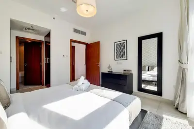 a bedroom with a large white bed and a mirror at Standpoint A, Downtown - Contemporary One Bedroom in Dubai