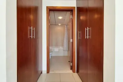 a bathroom with wooden doors and a bath tub at Standpoint A, Downtown - Contemporary One Bedroom in Dubai