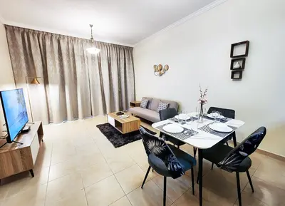 a living room with a table and chairs and a couch at RH- Unwind and Relax, 1BR, Burj View from balcony, Downtown in Dubai