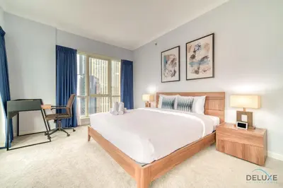 a bedroom with a large bed and a desk at Alluring 2BR at Al Majara 1 Dubai Marina by Deluxe Holiday Homes in Dubai