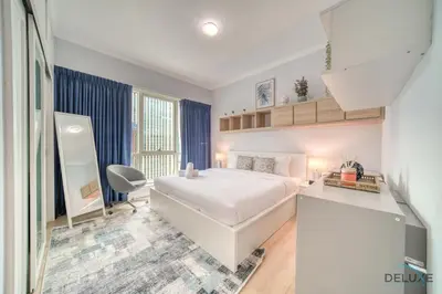 a bedroom with a white bed and a desk at Alluring 2BR at Al Majara 1 Dubai Marina by Deluxe Holiday Homes in Dubai
