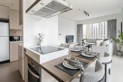 a kitchen and living room with a table and chairs at Frank Porter - West Avenue in Dubai