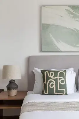 a bed with a green and white pillow on it at Frank Porter - West Avenue in Dubai