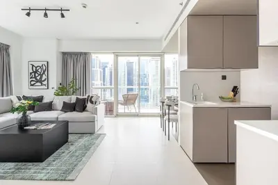 a kitchen and living room with a couch and a table at Frank Porter - West Avenue in Dubai