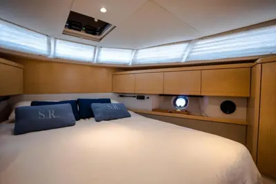 a large bed in a boat with two blue pillows at Yacht Experience - Stella Romana in Dubai